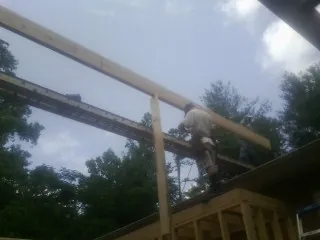 Carpenter setting a ridge beam over a new addition frame — Ice Dam Removal by Roofing Brothers in Nicholson